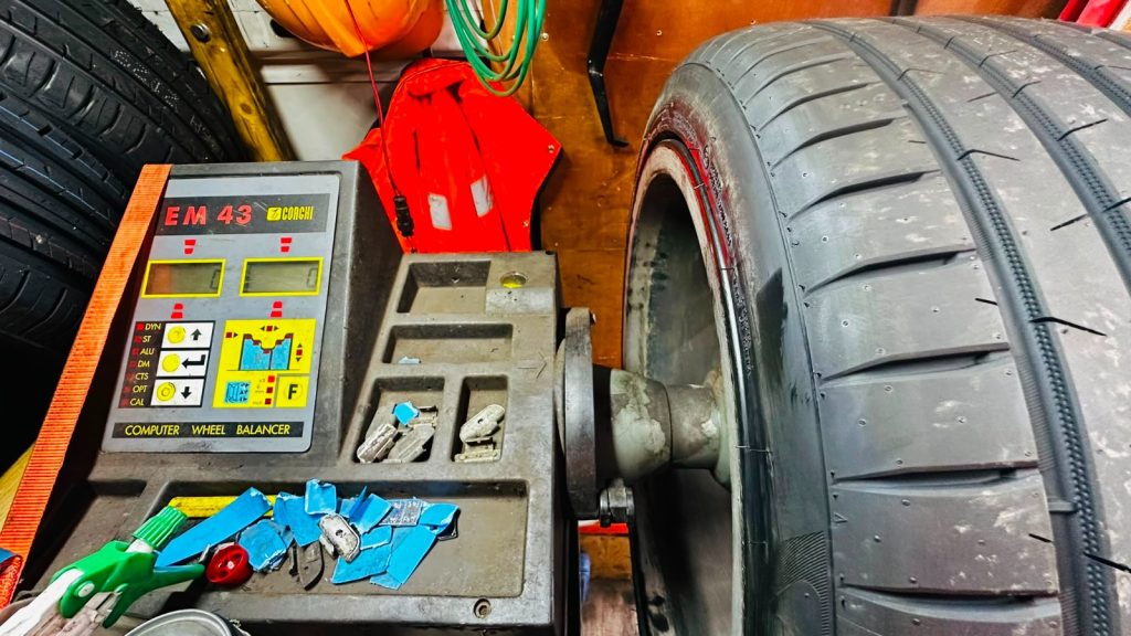 Wheel balancing machine inside a mobile tyre service van during a tyre replacement in Birmingham.